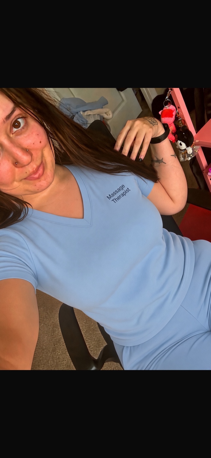 Julia, your massage provider, wearing blue massage therapist scrubs